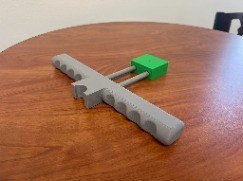 Gray launcher body with the plunger handle inserted during a fit test