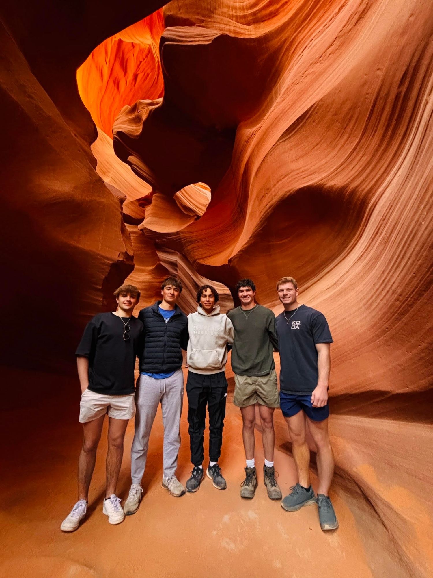 Friends standing in the glowing orange walls of Antelope Canyon